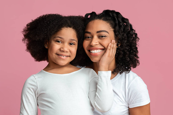Single zwart mam poseren naar camera met haar schattig dochtertje - Foto, afbeelding