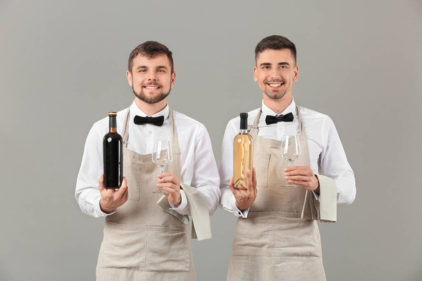 Portrait of waiters on grey background - Photo, Image