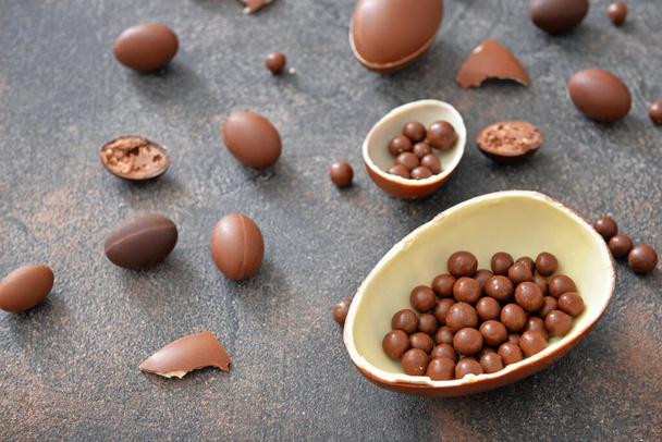 Шоколадні яйця та цукерки на сірому столі
 - Фото, зображення