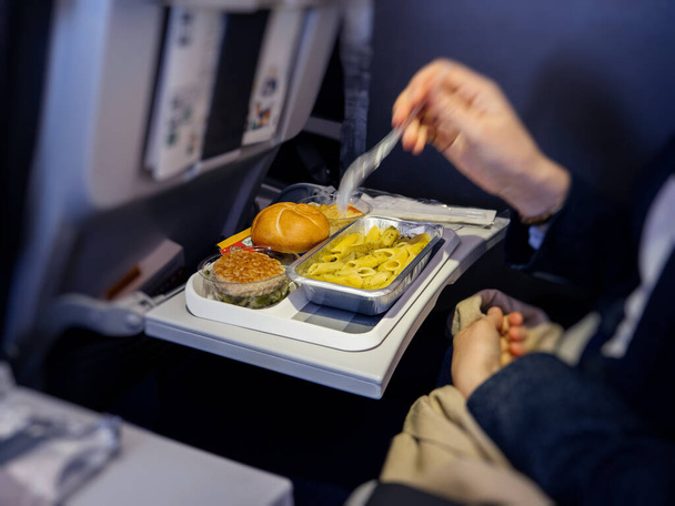 Woman eating in business class food airplane - Фото, изображение