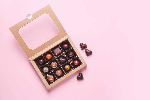 Box with delicious chocolate candies on color background - Photo, image