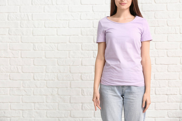 Young woman in stylish t-shirt on white background - Foto, afbeelding