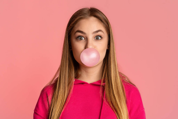 Buborék a rágógumiból. Lány rózsaszín háttér - Fotó, kép