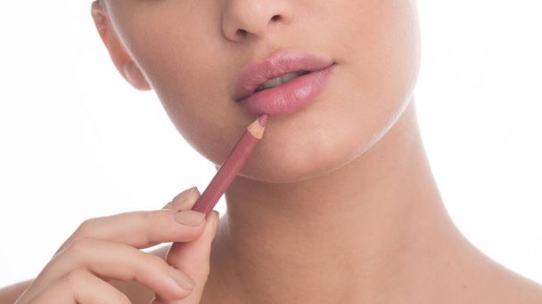 Femme méconnaissable appliquant une couche de lèvre nue en studio
 - Photo, image