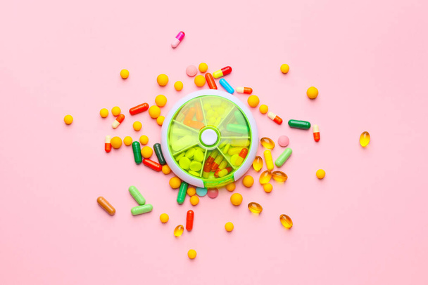 Contenedor con pastillas sobre fondo de color
 - Foto, Imagen