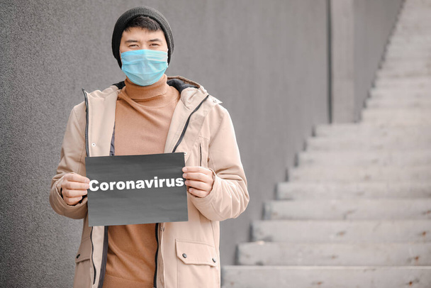 Şehir caddesinde koruyucu maske takan Asyalı adam. Coronavirüs salgını kavramı - Fotoğraf, Görsel