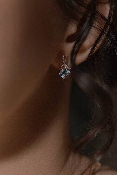 gold earring on woman's ear - Foto, immagini