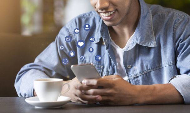 Усміхнений африканський підліток використовує мобільний телефон з функціональними кнопками
 - Фото, зображення
