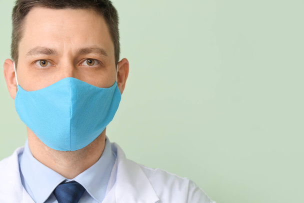 Doctor in protective medical mask on color background - Foto, afbeelding