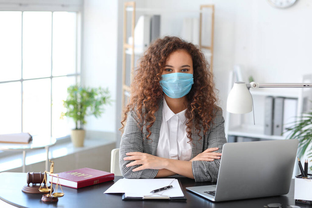 Vrouwelijke advocaat in beschermende masker werken in het kantoor - Foto, afbeelding