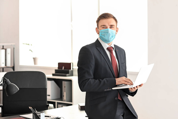Man advocaat in beschermende masker werken in het kantoor - Foto, afbeelding