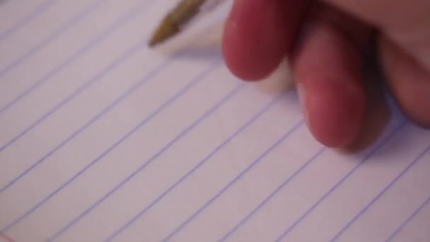 Ręka mężczyzny trzymającego długopis i piszącego na notatniku w paski. Pisał w pamiętniku lub liście, odrabiał lekcje, zapisywał kolczyki.. - Materiał filmowy, wideo