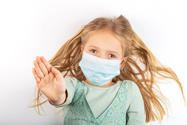 Coronavirus and Air pollution pm2.5 concept. Little russian girl wearing mask for protect during covid-19 quarantine. Prevention epidemic. Stay at home campaign - Photo, image