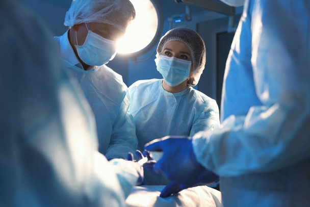 Ammattikirurgien ryhmä, joka suorittaa leikkauksen klinikalla
 - Valokuva, kuva