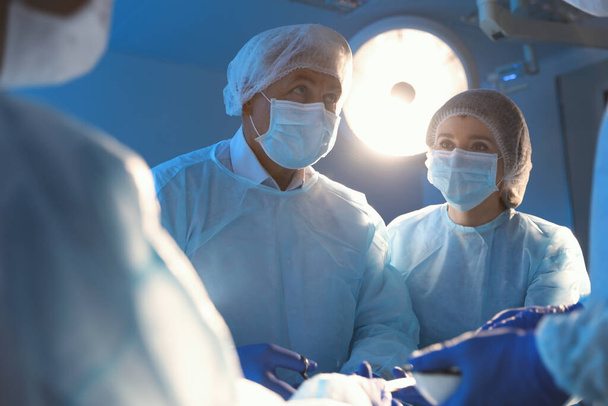 Команда профессиональных врачей, выполняющих операции в операционной - Фото, изображение
