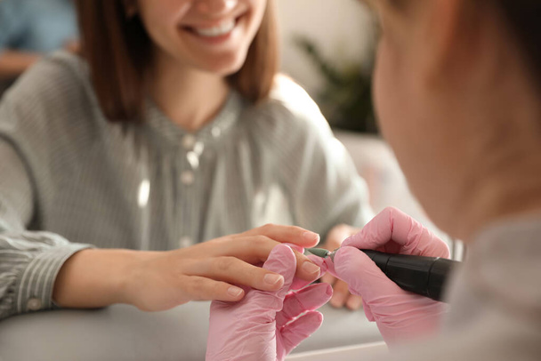 Professional manicurist working with client in beauty salon, closeup - Foto, Imagen