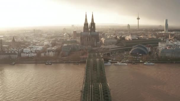 AERIAL: Vista sobre el Puente de Colonia Hohenzollern y vista de la Catedral y la Torre de TV en la hermosa luz del sol brumosa
  - Imágenes, Vídeo
