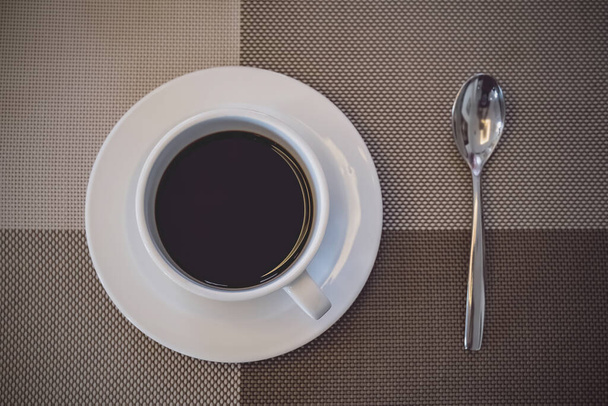 eine Tasse Kaffee bereit auf dem Tisch zur Frühstückszeit zum Aufwachen und Erfrischen am Morgen vor der Arbeitszeit - Foto, Bild