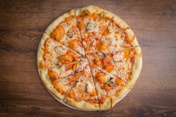 Deliciosa pizza fresca servida en mesa de madera - Foto, imagen