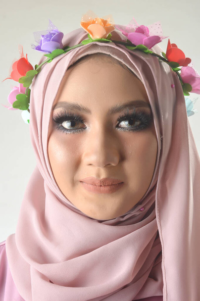 Portrait Belles filles asiatiques musulmanes portant une chemise musulmane rose et une bande de fleurs, une photo de studio avec un fond blanc
 - Photo, image