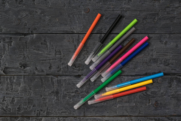 A set of colorful markers on a dark wooden table. - Fotografie, Obrázek