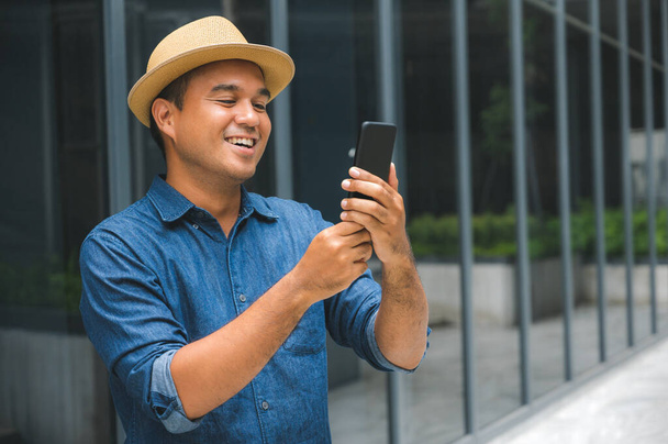 fiatal ázsiai férfi használ smartphone. - Fotó, kép