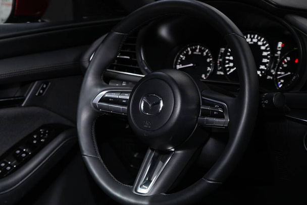 Novosibirsk, Russia  March 03, 2020  Mazda 3, Auto interior: steering wheel with red logo  Mazda and  speedometer and tachometer - Foto, Imagem