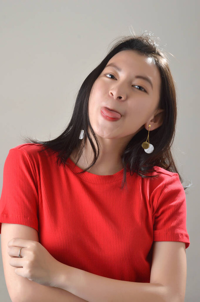 mooi aziatisch chinees meisje, gekleed in rood casual met gezichtsuitdrukking in een witte bakground fotostudio - Foto, afbeelding