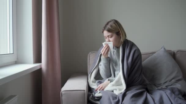 A girl with tired eyes sits opposite the onk. He is sick and blows his nose. Symptom of Orvi, coronavirus influenza, acute respiratory infections, allergies, sinusitis. - Filmagem, Vídeo