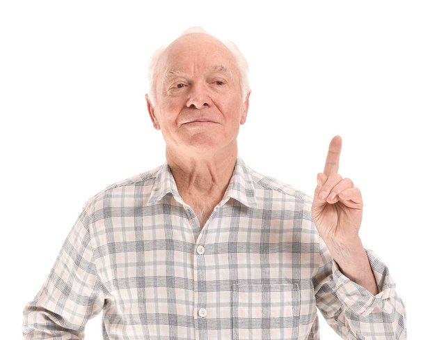 Portret van oudere man met opgeheven wijsvinger op witte achtergrond - Foto, afbeelding