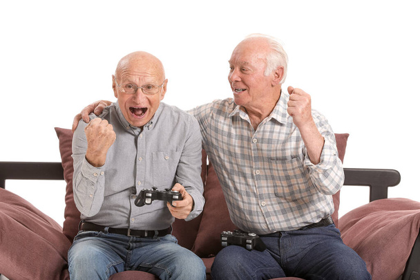 白地でビデオゲームをプレイする高齢者の肖像画 - 写真・画像