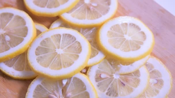 Close-up vista superior frescura limão fatiado na placa de corte girando sobre a mesa
 - Filmagem, Vídeo