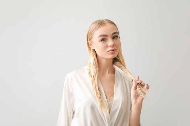 Beautiful young woman with healthy hair on grey background - Φωτογραφία, εικόνα