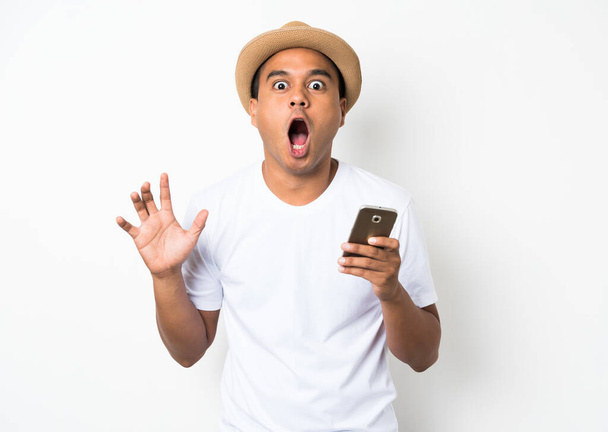 Verrast en geschokt aziatische man op zoek smartphone - Foto, afbeelding