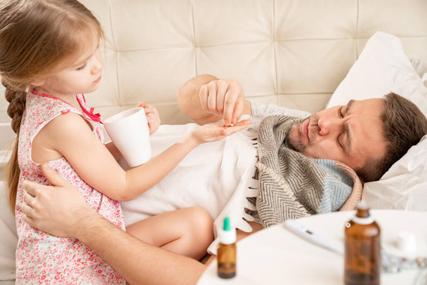 little girl gives cure of sick dad. family care. - Fotografie, Obrázek