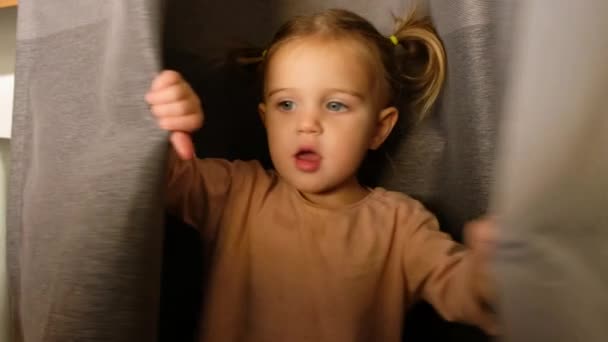 Kleines Mädchen versteckt sich hinter Vorhang - Filmmaterial, Video