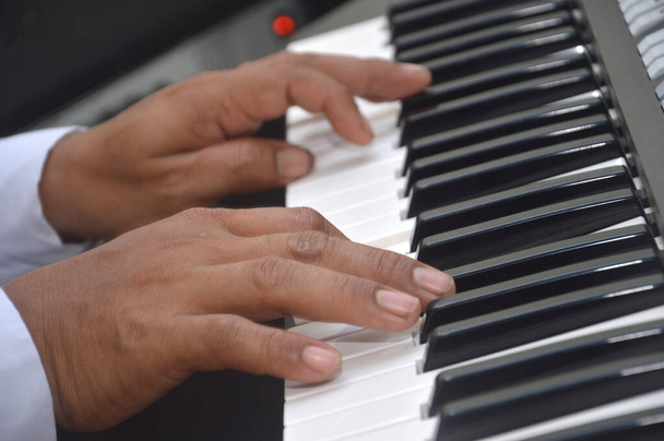 vingers van een man die piano speelt - Foto, afbeelding
