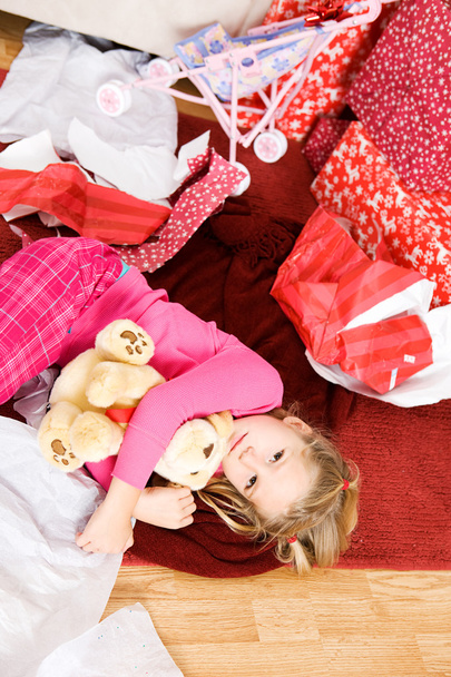 Christmas: Girl Lying On Floor In Wrapping Paper - Фото, изображение