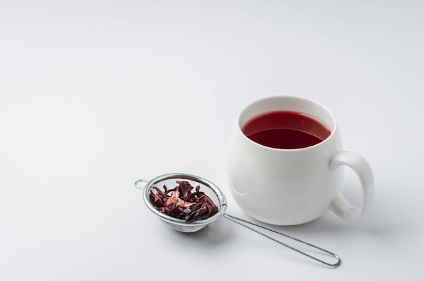 red hibiscus tea in a white mug and dry blossom isolated on white background, copyspace - Фото, зображення