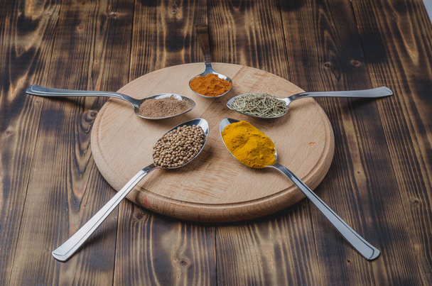 Set of various aromatic colorful spices in spoons on a wooden round support.  - Fotoğraf, Görsel