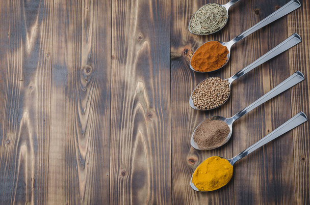 Set of various aromatic colorful spices on a wooden table. Top view and copyspace. Ingredients for cooking - Fotó, kép