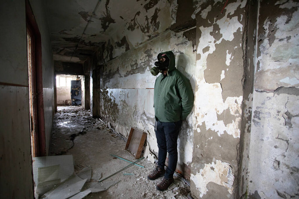  Post apocalyptic survivor in gas mask in a ruined building. Environmental disaster, armageddon concept. - Фото, изображение