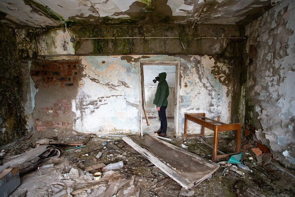  Post apocalyptic survivor in gas mask in a ruined building. Environmental disaster, armageddon concept. - Foto, imagen