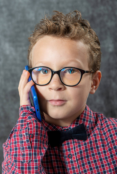 a young boy using a smartphone for talking - Foto, afbeelding