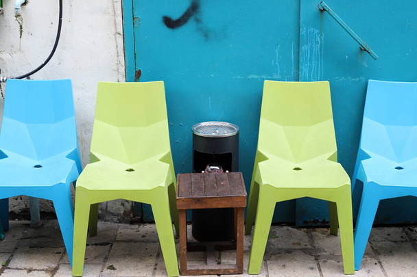Ein Stuhl und ein Tisch stehen in einem Café am Ufer des Mittelmeers im Norden Israels. Stadtfotografie  - Foto, Bild
