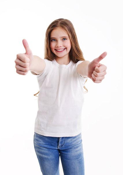 Portrait of adorable smiling little girl child in jeans and white t-shirt with two fingers up isolated on a pink background - Foto, Bild