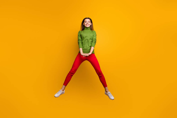Teljes hosszúságú fotó a pozitív vidám lány élvezni téli nyaralás ugrás viselni alkalmi stílusú modern ruhát elszigetelt felett élénk színű háttér - Fotó, kép