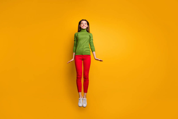 Full body photo of positive cheerful girl have free time jump feel candid emotions wear casual style clothing isolated over yellow color background - Фото, зображення