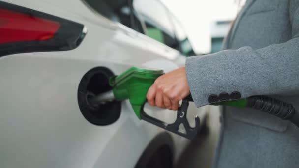 Een vrouw vult benzine in haar auto bij een tankstation. Langzame beweging - Video