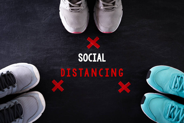 Social Distancing concept. shoes with red cross on blackboard by far from other by using social distancing concept to stop the coronavirus from spreading. - Photo, Image